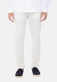 Pantaloni in cotone bianco a coste con vestibilità slim, caratterizzati da una finitura testurizzata e tasche laterali, abbinati a scarpe slip-on in suede blu navy.