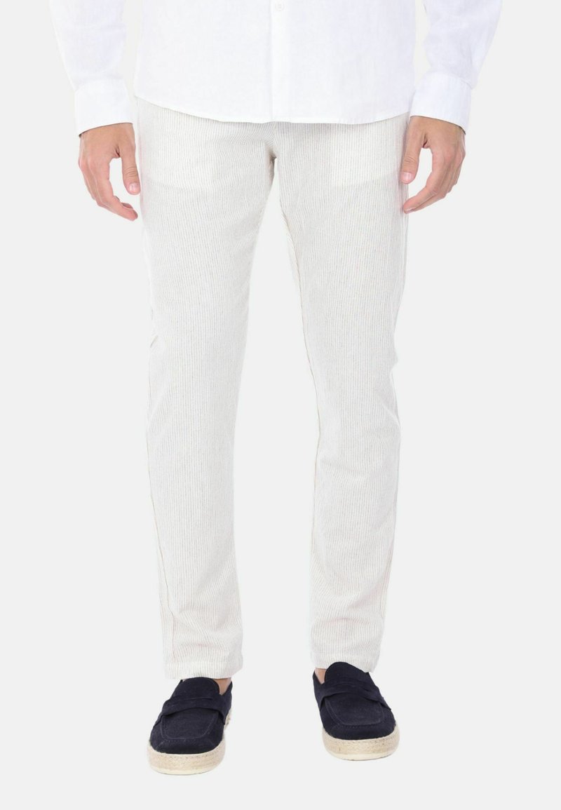 Pantaloni in cotone bianco a coste con vestibilità slim, caratterizzati da una finitura testurizzata e tasche laterali, abbinati a scarpe slip-on in suede blu navy.