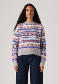 Grijze gebreide trui met een ronde hals, versierd met meerkleurige motieven in blauw, rood, geel en wit, gemaakt van zacht breimateriaal.