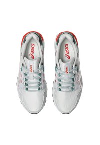 Hvide atletiske sko med mesh-overdel, pink og teal accenter, reflekterende detaljer og sort gummisål. Inkluderer snørebåndsdesign og logo.