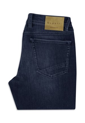 Dunkelblaue, gefaltete Jeans mit einer Gesäßtasche und einem hellbraunen Lederetikett mit der Aufschrift „bugatti handcrafted“ am Taillenbund.