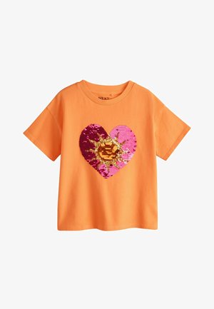 Orange kortærmet T-shirt med et stort paliet-hjerte design, der har pink, lilla og gyldne solstrålemønstre på forsiden.
