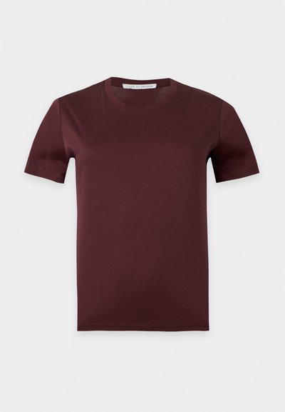 Απλό σκούρο καφέ κοντομάνικο T-shirt με στρογγυλή λαιμόκοψη και ετικέτα "Tiger of Sweden" μέσα στο γιακά σε ανοιχτό γκρι φόντο.