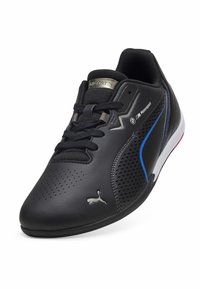 Černá kožená sportovní bota s perforovaným designem, modrými akcenty, texturovanými tkaničkami a logem Puma. Nízký profil s bílou podrážkou.