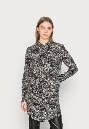 Chemise à manches longues en bleu marine foncé avec un léger motif à pois, dotée d'un col et d'une coupe droite. Texture de tissu lisse.