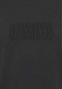 Czarna bawełniana koszulka z teksturowanym, tonowanym logo "ALLSAINTS" na piersi, z gładkim, miękkim wykończeniem i klasycznym krojem.