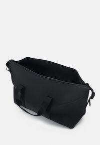 Borsa tote nera realizzata in tessuto texturizzato con doppi manici, ampio aperture e design elegante e minimalista. L'interno è spazioso e non foderato.