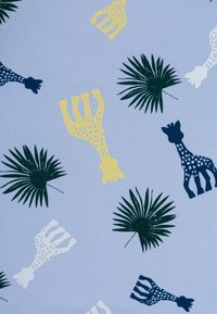 Tessuto azzurro chiaro con un motivo ripetuto di giraffe gialle, bianche e blu scuro, insieme a foglie di palma verdi con texture dettagliate.
