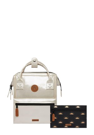 Metallic silberner Rucksack mit einer Front-Reißverschlusstasche, Lederakzenten und einem abnehmbaren schwarzen Täschchen mit einem Sonnenmuster.