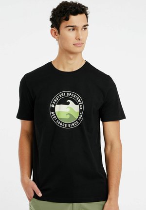 Musta puuvillainen t-paita, jossa on ymp circular graphic with green and white wave design ja teksti. Lyhyet hihat ja pyöreä kaula-aukko.