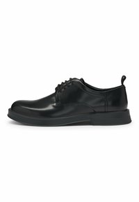 Black leather lace-up shoes with a rounded toe, smooth surface, low-profile rubber sole, and a pull tab at the heel for easy wear.