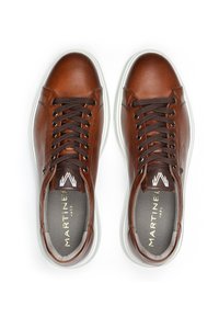 Ruskea nahkainen sneakers-pari, jossa on valkoiset pohjat ja tummanruskeat nauhat, brändätty "Martinel 1973" näkyvissä pohjallisissa.
