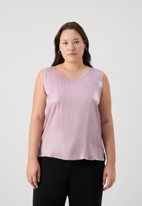 Lys rosa satin uten ermer med rund halslinning. Glatt tekstur, myk glans, flytende passform og avrundet hem. Brukt med svarte bukser.