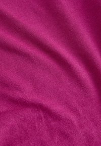 Fuchsiová bavlněná látka s hladkou strukturou, která má jemné žebrování a mírné skládání, vytvářející měkké vlny na povrchu.