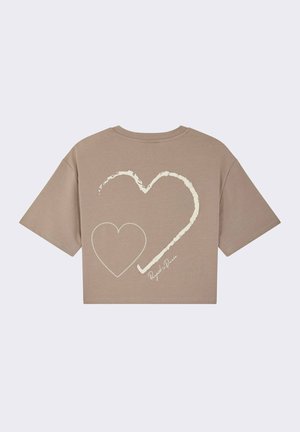 Cropped beige t-shirt featuring a large, outlined heart design in cream on the back, with a stitched heart detail and printed text.