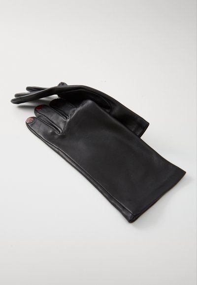 Gants en cuir noir avec une texture lisse, présentant un design à doigts allongés et des accents rouges sur les pads des doigts. Pose plate, non boutonnée.