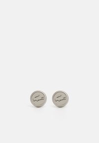 Sølvfarget metall cufflinks med sirkulær form, med en hevet krokodille-logo og teksturert kantdetalj.
