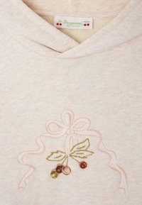 Felpa rosa chiaro con cappuccio regolabile, caratterizzata da un design ricamato di fiocchi e foglie con perline decorative rosse e verdi. Etichetta del brand visibile.