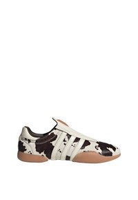 Sneaker featuring a cowhide design in white with brown spots, leather accents, and a rubber sole with a rounded shape.