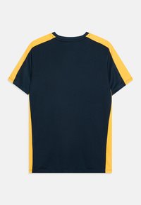 Camisa deportiva azul marino con mangas raglán amarillas, que presenta una tela texturizada y un cuello redondo. Diseño ligero adecuado para deportes.