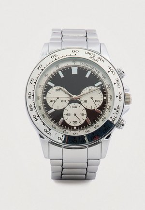 Zilverkleurig roestvrijstalen polshorloge met een zwarte wijzerplaat, drie subdials, tachymeterschaal en een gepolijste metalen armband.