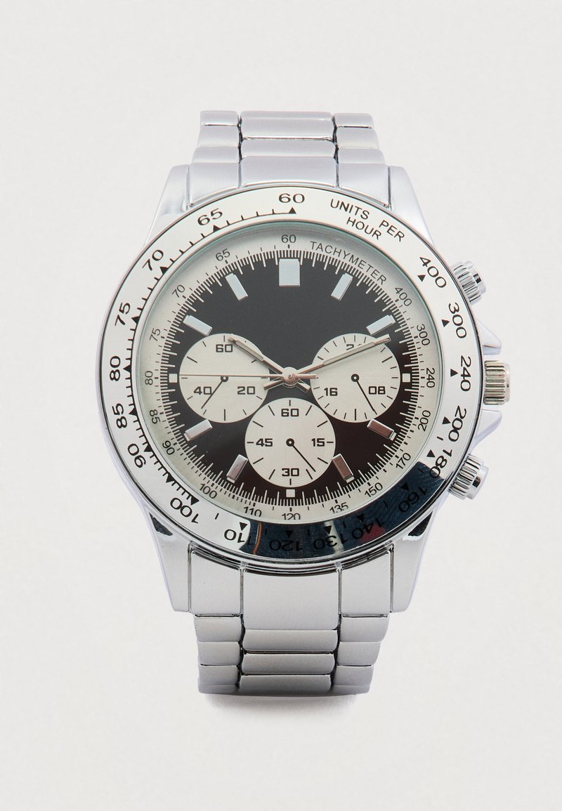 Ασημένιο ρολόι χειρός από ανοξείδωτο ατσάλι με μαύρο καντράν, τρία υποκαντράν, κλίμακα ταχύμετρου και γυαλιστερό μεταλλικό μπρασελέ.