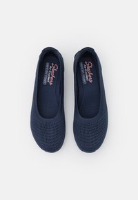 Marine slip-on sko laget av pustende mesh-stoff, med en teksturert overflate og minneskumsåler for komfort.