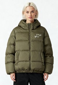 Veste matelassée vert olive avec fermeture éclair, capuche, logo avec un cœur et une flèche, et ourlet et poignets élastiqués.