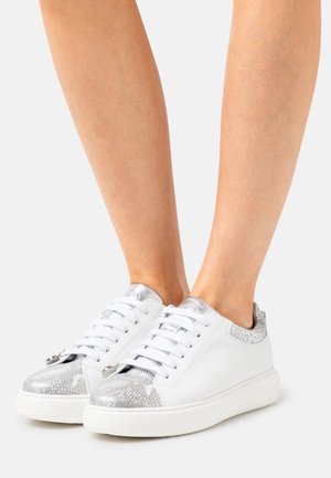 Sneaker bianchi con un accento testurizzato argento sulla punta e sul tallone; design con lacci; materiale liscia e suola in gomma.