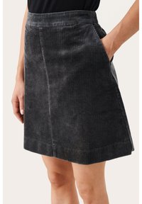 Jupe en velours côtelé gris avec des côtes verticales, dotée de poches latérales et d'une taille ajustée. La texture est douce et légèrement brillante.