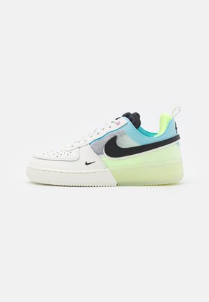 Baskets Nike blanches et bleu clair avec logo noir, semelle vert clair et doublure intérieure jaune fluo, vues de profil sur fond blanc.