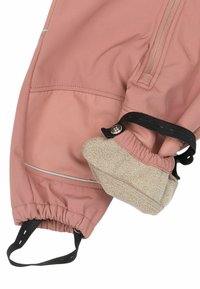Vodoodolné rúžové oblečenie s elastickými manžetami, zipsovou vreckom a mäkkou béžovou fleecovou podšívkou, zvýraznené reflexnými pruhmi.