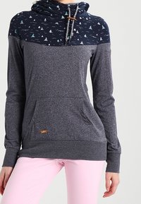 Marinblå och grå tröja med huva, med ett mönstrat övre parti som har små segelbåtsmotiv, en känguruficka och dragsko för huvan.