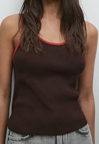 Bruine geribde tanktop met rode accenten langs de halslijn en banden, met een aansluitend ontwerp en gestructureerde stof.