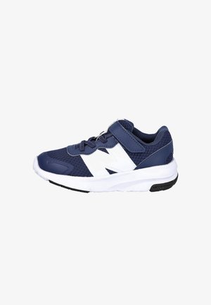 Zapatilla deportiva azul marino con parte superior de malla, acentos blancos y una correa de Velcro. Punta redondeada y suela gruesa blanca con parte de agarre negra.