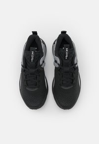 Baskets de sport noires avec un upper en mesh, au design épuré, accentuées de gris, avec un système de laçage et une semelle texturée pour une meilleure adhérence.