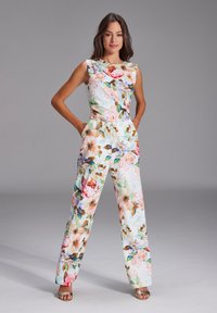 Blumenoverall in Pastellfarben mit ärmellosem Design, weitem Bein und tailliertem Schnitt. Hergestellt aus leichtem Stoff mit einem lebhaften Blumenmuster.