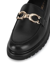 Čierne kožené loafery s akcentom v zlatom tóne, okrúhlou špičkou a textúrovanou podrážkou. Obsahuje prešívanie pozdĺž okraja.