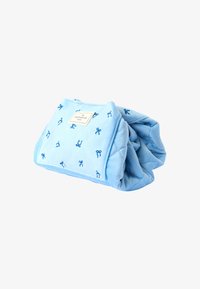 Manta de forro polar azul con un diseño acolchado, con patrones de lazo azul y una etiqueta. Suave y compacta, plegada para almacenamiento.