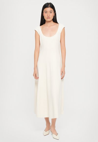 White, sleeveless midi dress with a scoop neck, structured bodice, and flowing skirt. Smooth fabric with minimal detailing and no patterns.