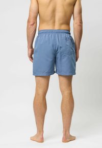 Mėlynos maudymosi šortai, pagaminti iš lengvos medžiagos, su elastingu juosmeniu, viena užpakaline kiemute ir kasdieniu, virš kelių ilgio dizainu.