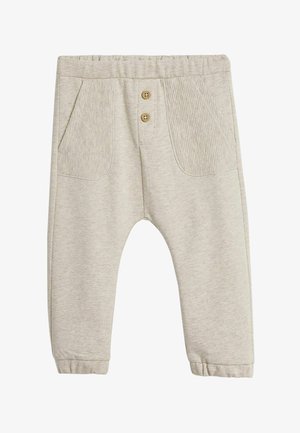 Beige peuterbroek met elastische taille, twee geribbelde voorzakken, twee houten knopen en elastische boorden bij de enkels.