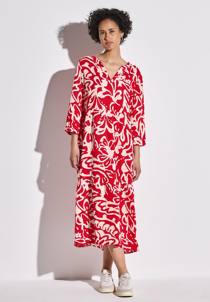 Maxikleid mit rot-weißer Blumenmusterung, V-Ausschnitt, Dreiviertelärmeln und gestuftem Rock, aus leichtem Stoff gefertigt.