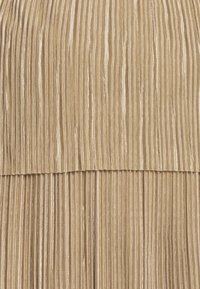 Tissu plissé beige avec des rayures verticales ; la surface présente un léger brillant et une finition texturée, créant une apparence superposée en haut.