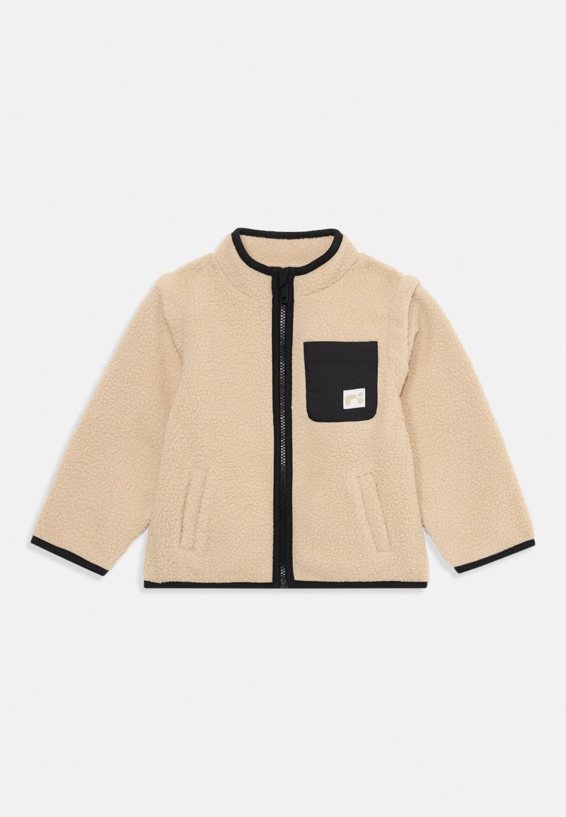 Beez fliisjakiga, millel on luku esiosa, must äär ja väike must tasku. Pehme tekstuur ja mugav lõige, ideaalne kihiliseks riietumiseks.