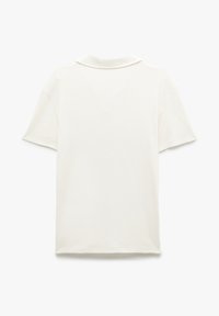 Kortärmad pikétröja i off-white med en mjuk, ribbad textur. Har en klassisk krage och en avslappnad passform. Bakvy visas.