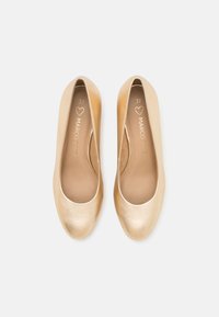 Ballerines dorées avec une finition métallique lisse. Design à bout rond et semelle intérieure rembourrée, marquées de la taille 37. Silhouette épurée.