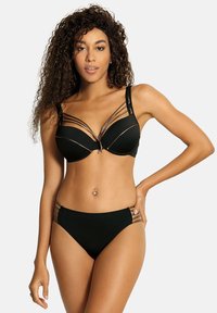 Czarny zestaw bikini z usztywnianym biustonoszem z metalowymi akcentami i wieloma cienkimi ramiączkami. Dół ma wycięcia po bokach z podobnymi detalami.