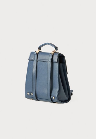 Piccolo zaino in pelle blu con doppie cinghie, manico superiore e ferramenta dorata su uno sfondo bianco uniforme.