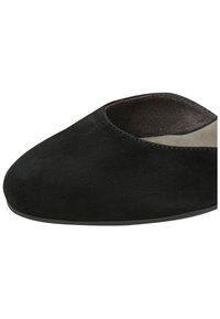 Chaussure plate en daim noir à enfiler avec bout arrondi et intérieur rembourré, vue en gros plan de côté.